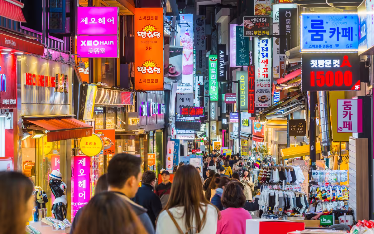 Calle principal de Myeongdong con tiendas y street food en Seúl