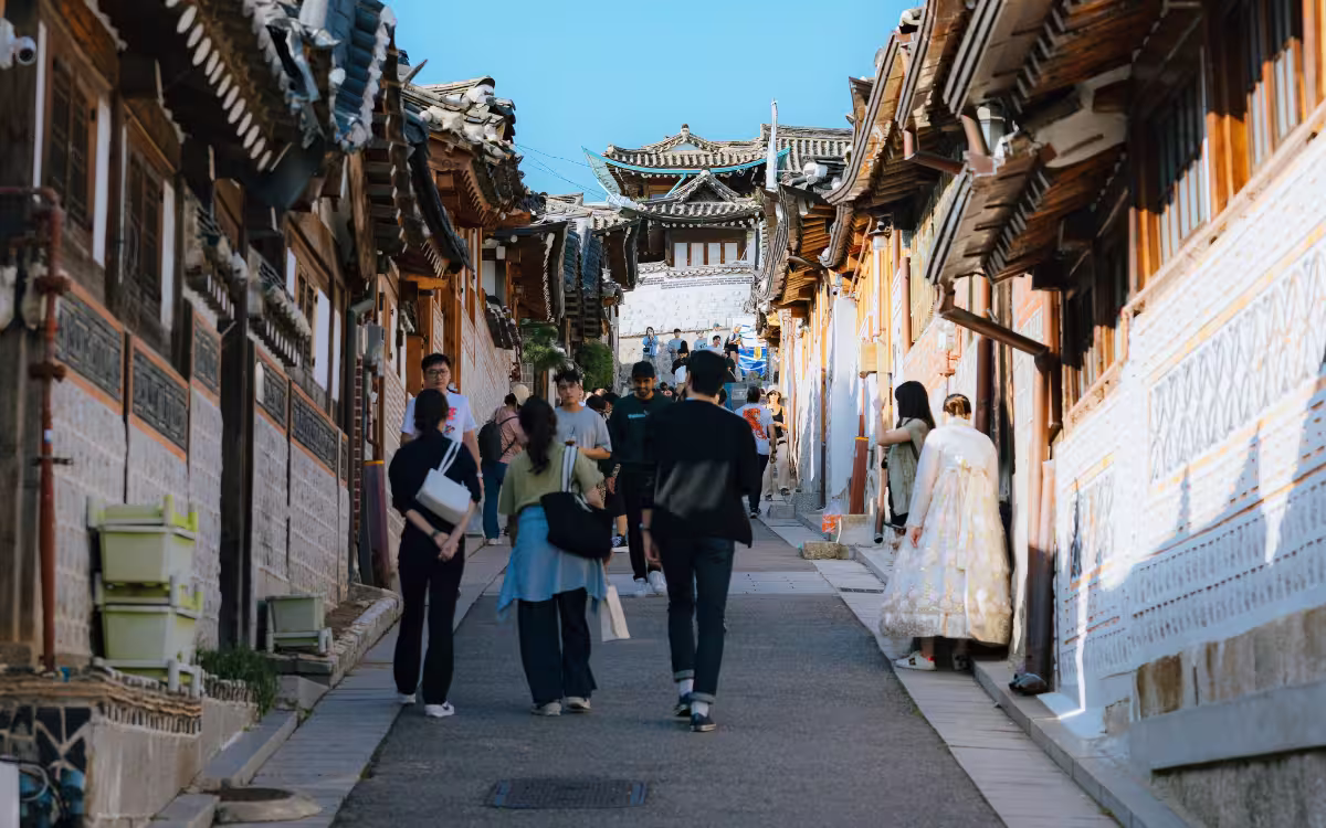 Turistas vestidos con hanbok caminando por Bukchon Hanok Village en Seúl